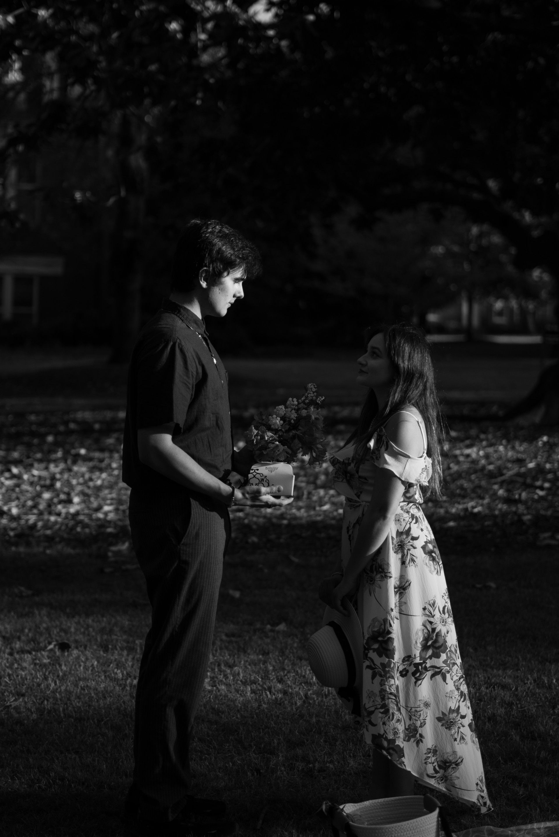 A black and white photo of a man looking wistfully at a woman.